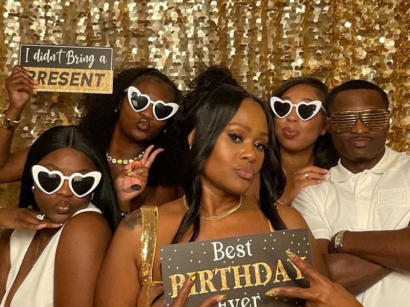 Guests posing at a VIMO Events digital photo booth with props